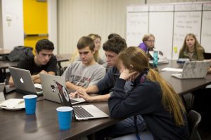 Editor and chief Rees Roggenstein and opinions editor Olivia Quebe instruct Feather staffers how to fix The Feather website.