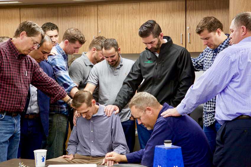 A group of FCS fathers (shoulder to shoulder), gather monthly to pray over the students at FCS. 