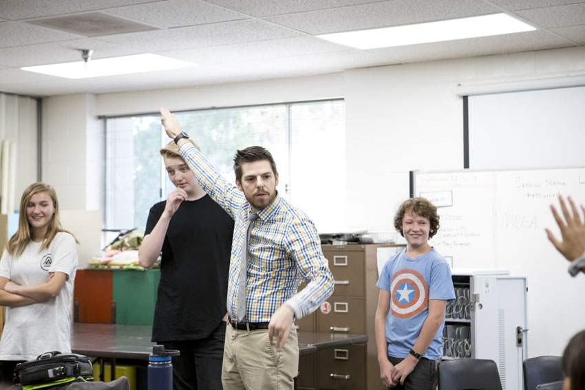 Drama teacher Kyle Dodson (middle) instructs students through a theatre exercise.