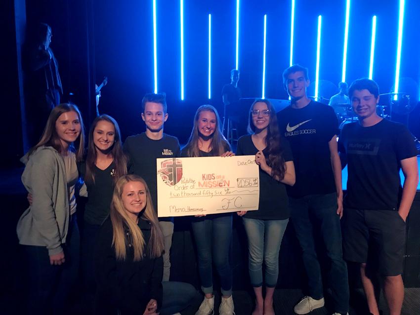 Kids on a Mission representatives receive a check from money raised at homecoming, Nov. 1.   