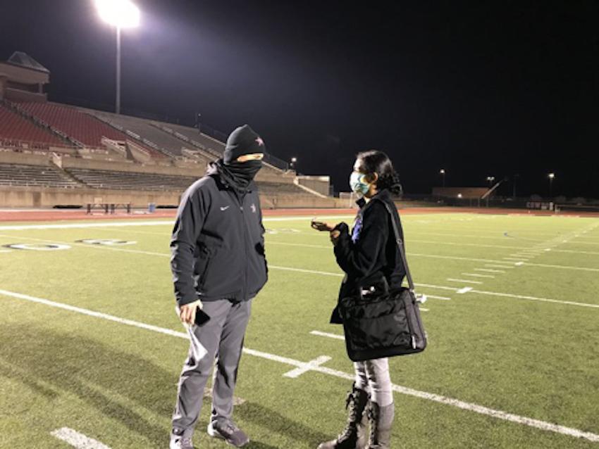 Coppell High School senior Sally Parampottil ’21, interviews Coppell head football coach Michael DeWitt at Buddy Echols Field on Dec. 4.
