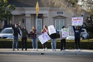 Students dance and wave signs in honor and support of Kids Day. 