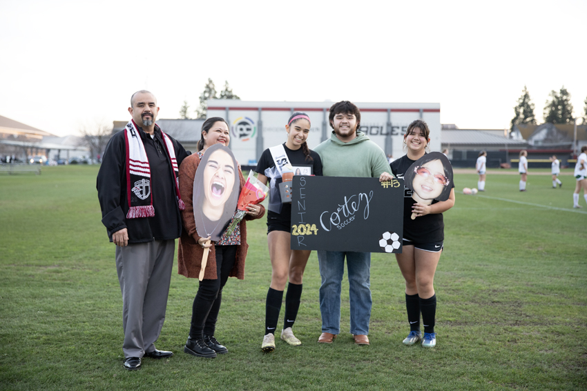 Senior, Serenity Cortez poses along side her family and younger sister, Maya Cortez, who also plays on the team, Feb. 13. 
