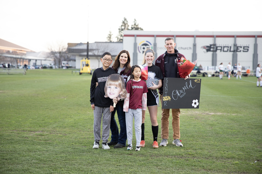 Senior, Jenna Obwald takes a picture alongside her siblings and parents, Feb. 13. 
