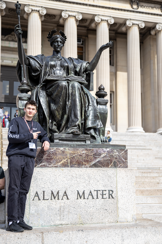 Feather staff Ian Palsgaard point with Alma Mater statue in Columbia 