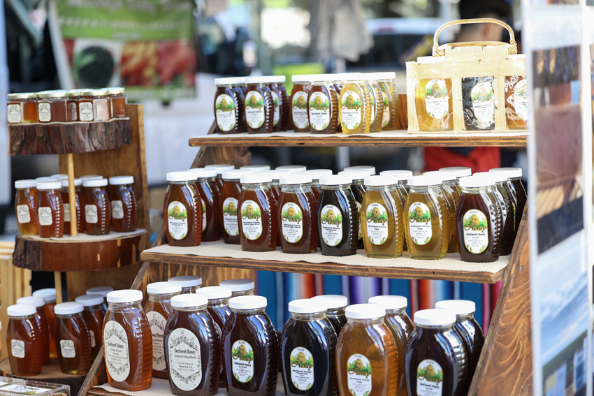 Local honey vendors display their variety of regular and infused honey such as cinnamon and fruit infused honey.