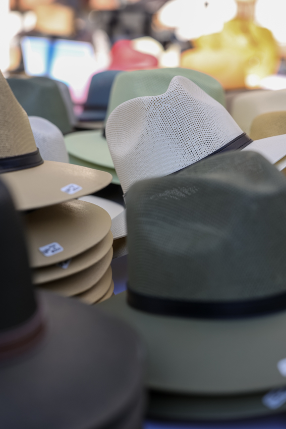 A variety of hats were on the stands, like cowboy hats and sun hats.