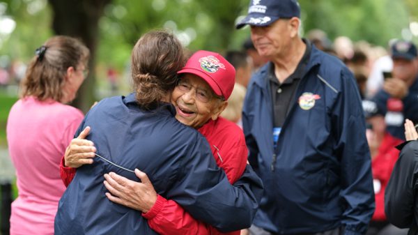 Arthur Dandridge greeted with hugs while exiting Arlington Cemetery.