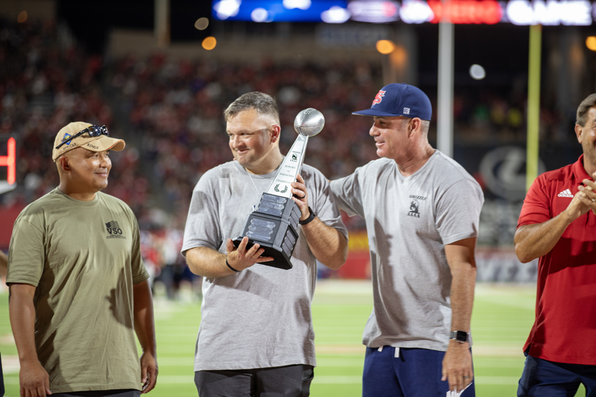 (Left to right) Chief Warrant Officer Steven Souphasith, LTC David Lovett and retired Colonel Shiloh Briggs, Lovett receives the Heroes night trophy for leading his team to victory, Sept. 14.