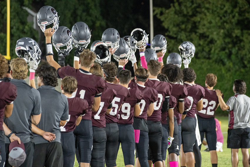 Fresno Christian football raises their helmets in respect of the National Anthem played before kickoff at every game, Oct. 4.