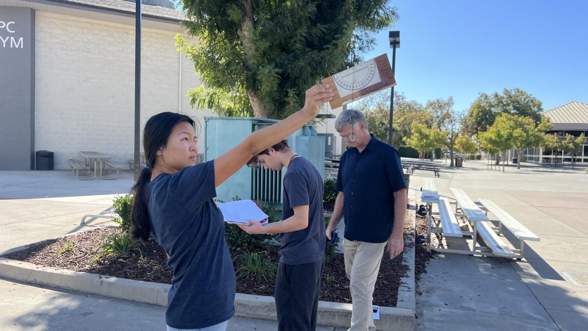 Student Laina Penland uses a sextant to find the angle of building six, Oct. 17.