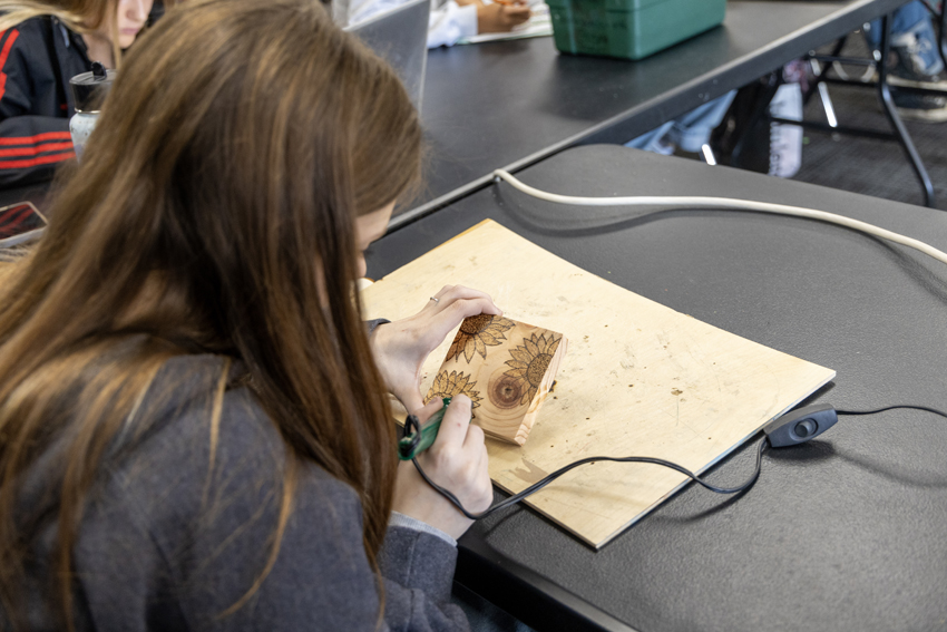 Marin Beasley '26 creating flowers for her woodburning project. 