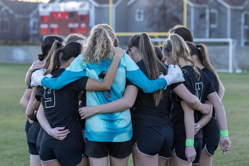 The FC girls soccer team huddle for a pregame prayer