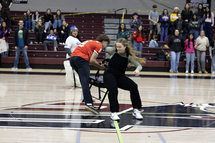 Tayla Tarlton, '26, and Ian Palsgaard, '25, fighting for the win in musical chairs for the 2025 Winter Sports Rally.