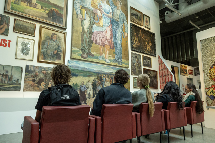 Owen Gainer, Ian Palsgaard, Delaney Meyers, Dorina Gilmore-Young, and Giada Gilmore-Young sit and talk about the art at the Museum of Communism.