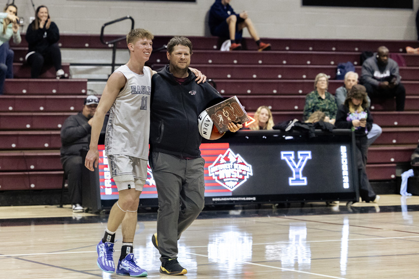 Aden Millwee, '25, is celebrated for his 1000th career points by Coach Penberthy and peers.