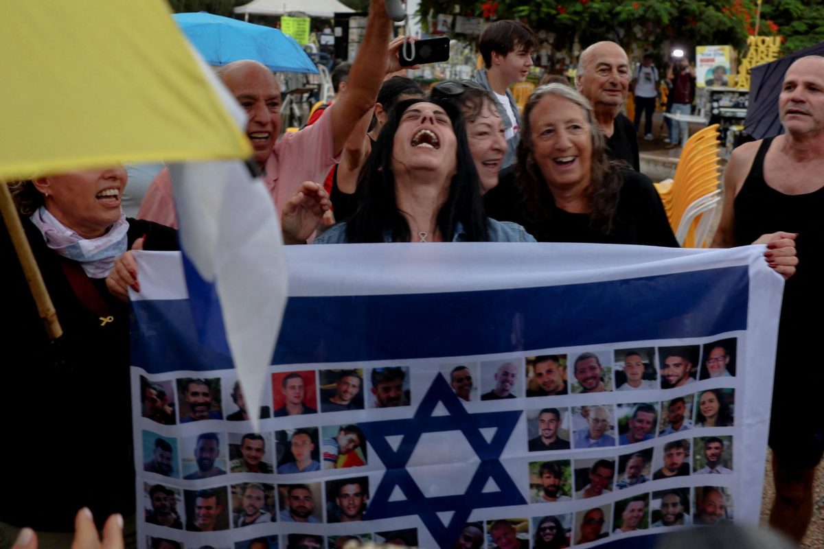 Einav Zangauker, the mother of hostage Matan Zangauker, reacts holding an Israeli flag with photos of hostages, after U.S. President Donald Trump announced that Israel and Hamas agreed on the first phase of a Gaza ceasefire, at the "Hostages square", in Tel Aviv, Israel, October 9, 2025. REUTERS/Ronen Zvulun