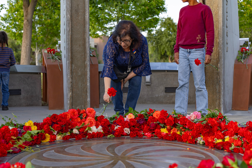 Woman lays a flower on the Armenian Eternity symbol during the Fresno State Armenian Genocide Commemoration on April 24.